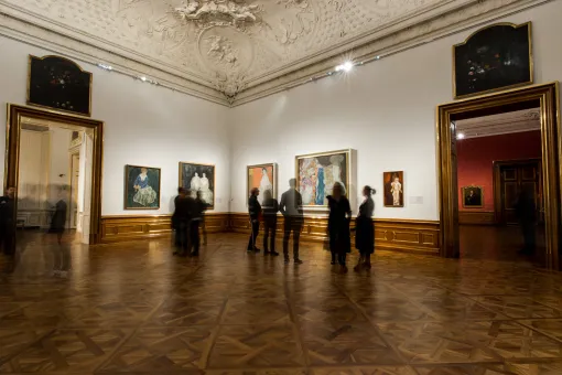 Menschen im Ausstellungsraum mit Gemälden von Gustav Klimt