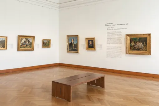Ausstellungsraum mit Biedermeier-Gemälden an der Wand
