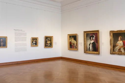 Ausstellungsraum mit Biedermeier-Gemälden an der Wand