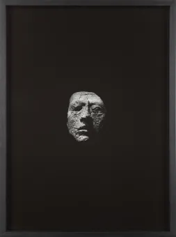 Skulptur eines Gesichts auf schwarzem Hintergrund