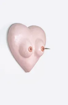 Objekt eines hautfarbenen Herzen mit Busen und Messer