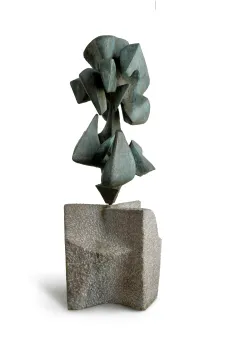 Bronzeskulptur mit tropfenähnlichen Formen auf einem grob behauenen Sockel aus grauem Stein