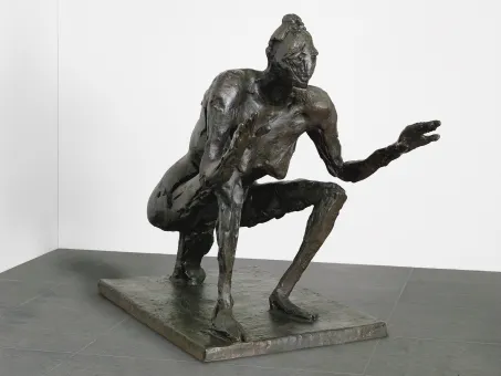 Bronzene Skulptur auf einem schlichten, rechteckigen Sockel, Figur ist in einer kauernden Haltung dargestellt, mit einem Arm ausgestreckt und einer gebückten, dynamischen Körperhaltung.