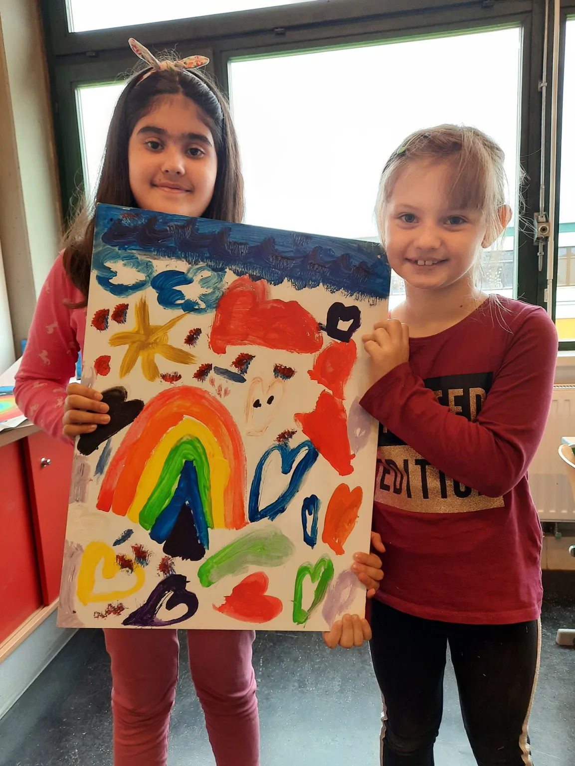 Schulkinder mit Regenbogenbild