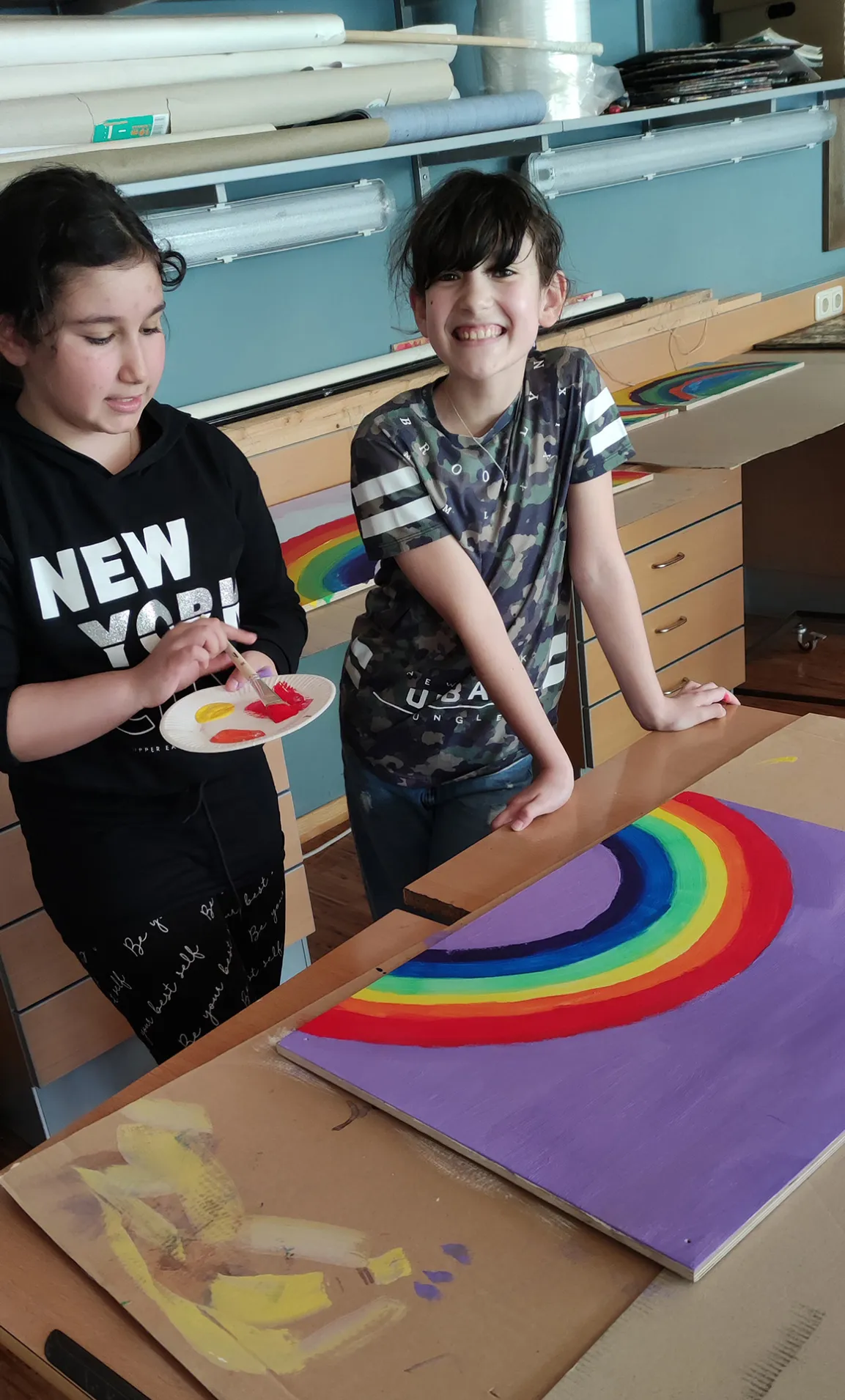 Schulkinder mit Regenbogenbild