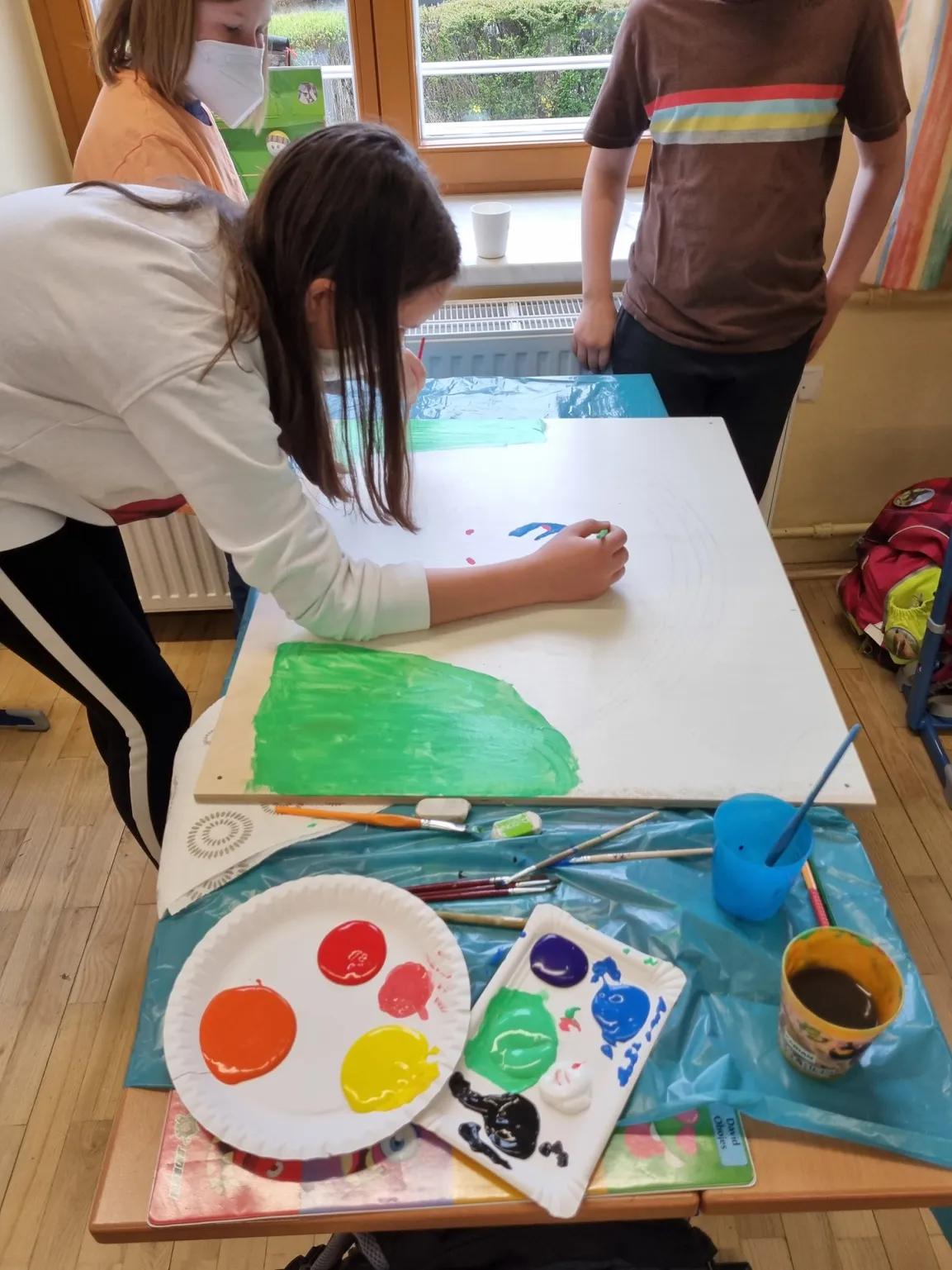 Schulkinder mit Regenbogenbild