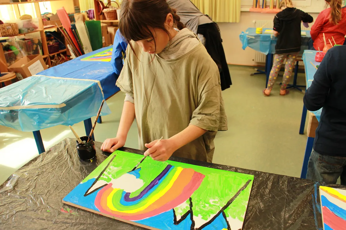 Schulkinder mit Regenbogenbild