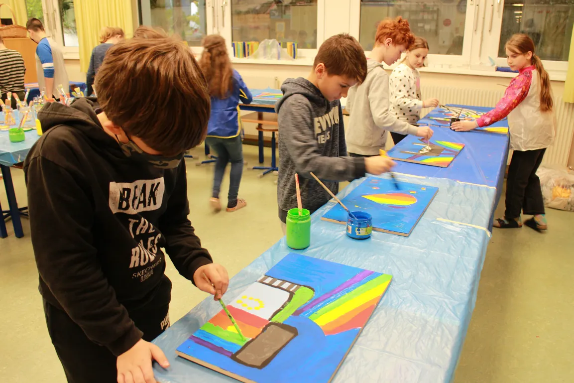 Schulkinder mit Regenbogenbild