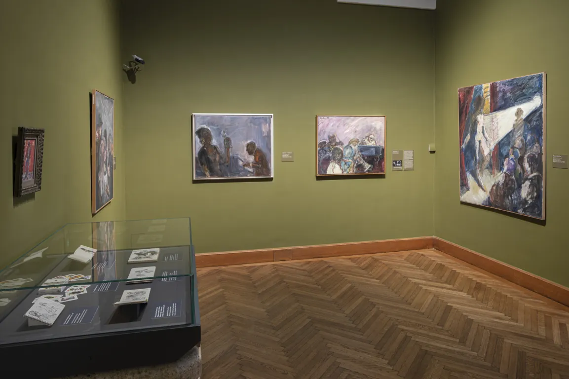 Ausstellungsraum mit gewölbter Decke und moosgrünen Wänden, darauf vage Bilder von Menschen
