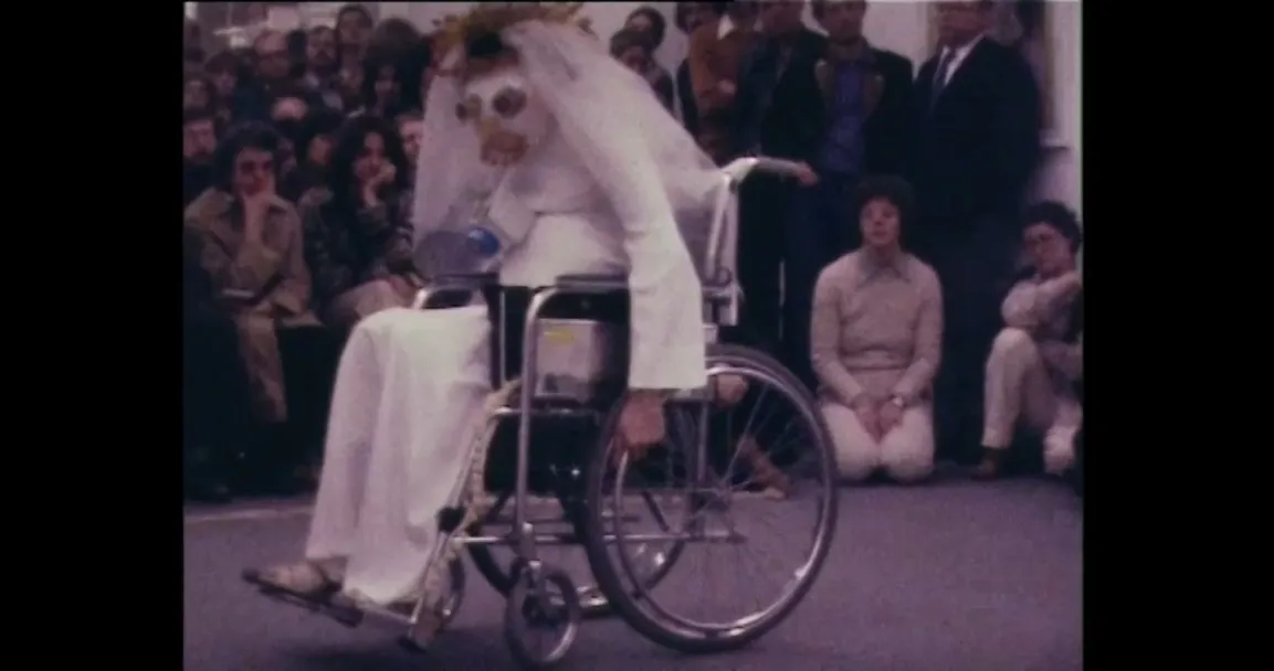 Still aus Renate Bertlmann, Die schwangere Braut im Rollstuhl, 1978; Performance-Dokumentation, Kunstverein Wien, 1978