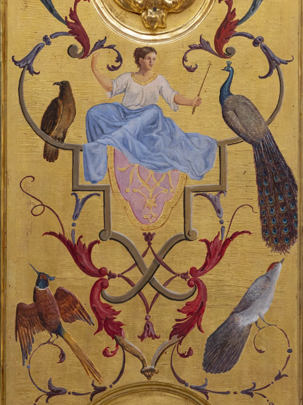 The goddess Juno: she wears a blue skirt, is surrounded by birds, holds a delicate scepter, and turns toward a peacock.
