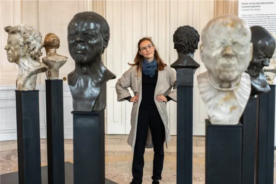Person im Museum beim Betrachten der Charakterköpfe von Franz Xaver Messerschmidt