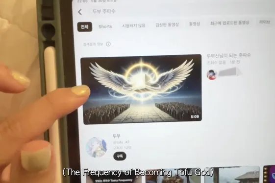 Finger der über ein Handydisplay scrollt auf dem Videos zu sehen sind