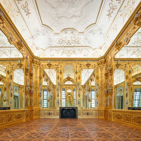 Eine Raumansicht. Die Wände sind mit großen Spiegeln und flächendeckend mit Blattgold verkleidet.