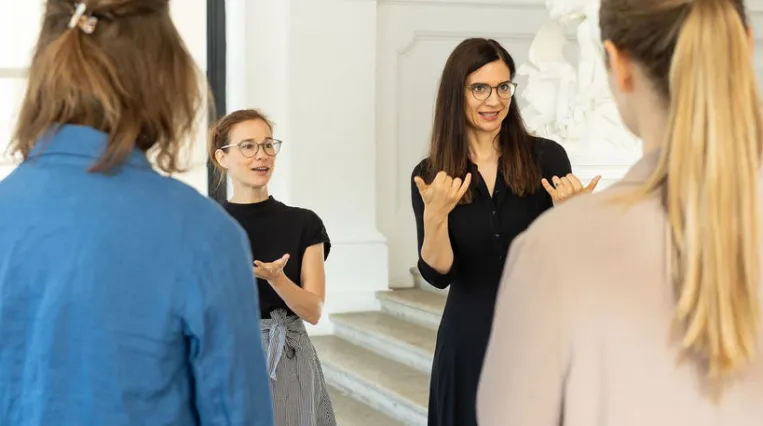 Menschen bei ener Führung mit Kunstvermittlerin und Gebärdendolmetscherin im Museum