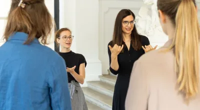Menschen bei ener Führung mit Kunstvermittlerin und Gebärdendolmetscherin im Museum
